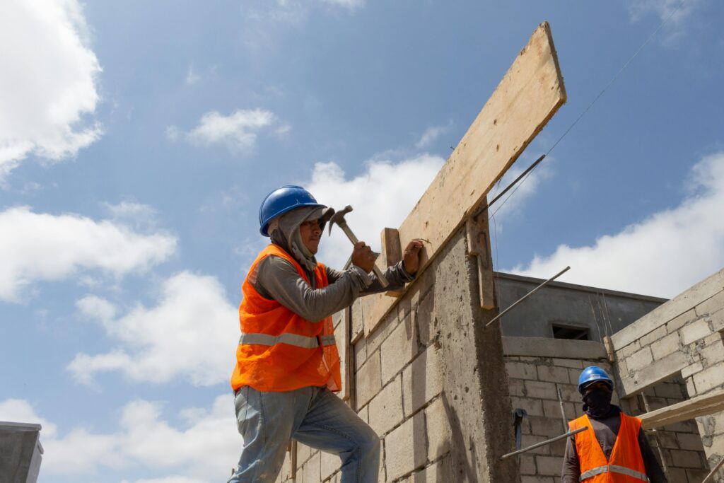 Construction workers building a structure in Ballenita, Ecuador under a clear sky.